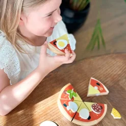 Pizza en porciones e ingredientes de madera - Mentari